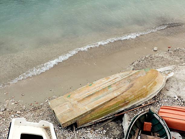 Abandoned boat on a quiet Croatian beach with weathered wood and soft tide