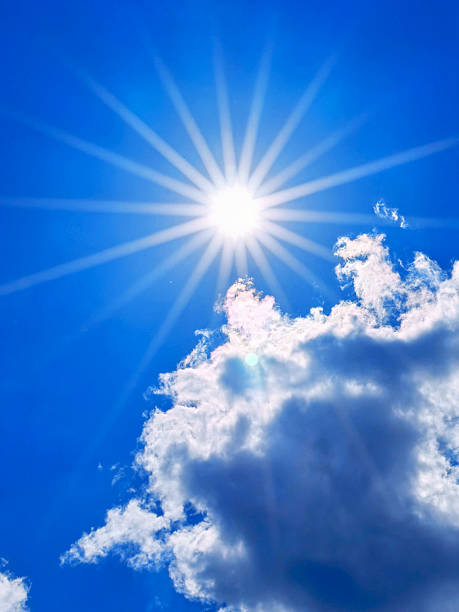 istock Bright sunshine filtering through fluffy clouds in a clear blue sky during midday 2226695738