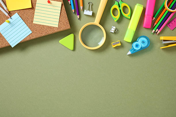 istock Flat lay colorful stationery on green background, featuring sticky notes, pencils, scissors, and highlighters. 2226698785