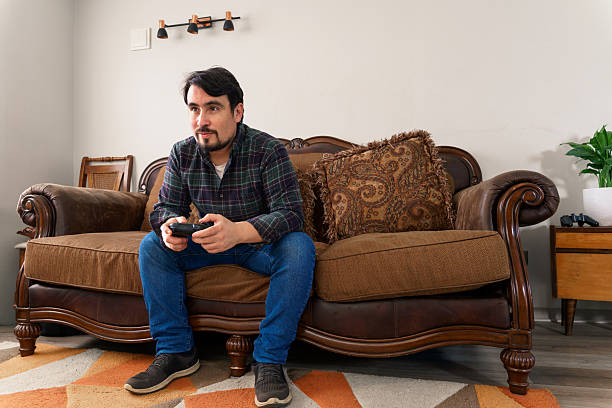 Mid adult man enjoying his free time playing video games in his living room