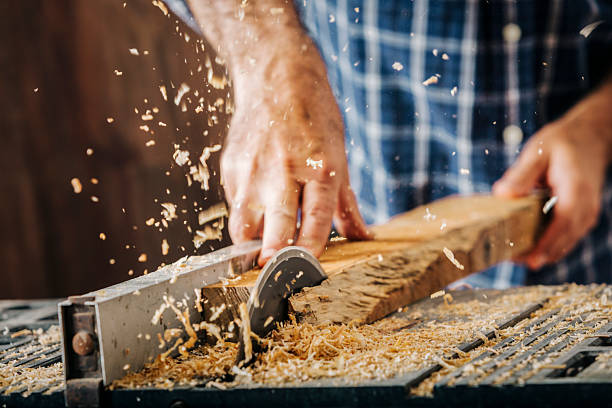istock Male carpenter using electric circular saw in home workshop with wood chips flying 2226702966