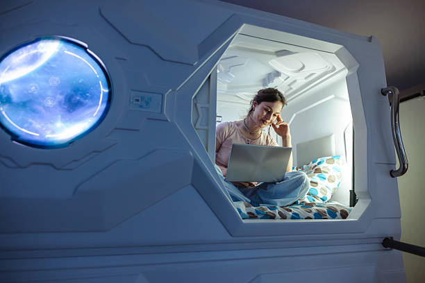 istock Young woman using a laptop inside a futuristic sleeping pod 2226704045
