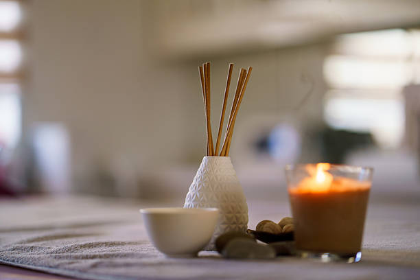 Candle, aromatic incense sticks, and decoration on a towel.