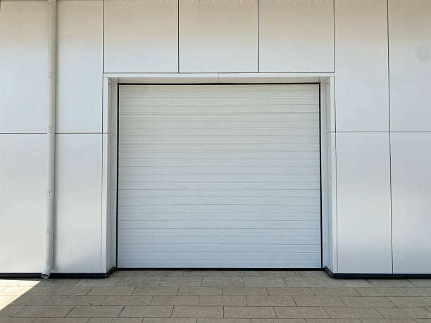 istock Closed automatic white metal roller shutter doors. Fragment of modern urban building,  front view. There may be garage, parking lot, storage room or store behind closed door 2226704235