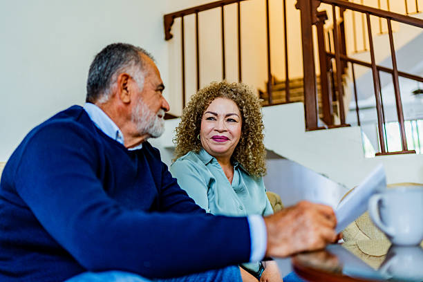 istock Senior couple talking and holding document at home 2226718577
