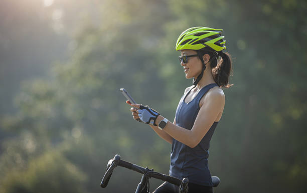 istock Woman cyclist using mobile phone in summer park 2226724869