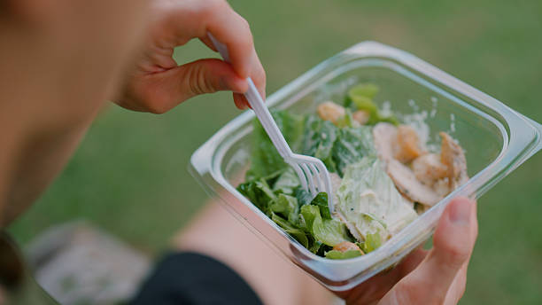 istock Young  man eating salad while resting from an exercise in a public park. 2226726402