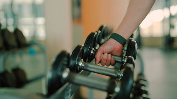 istock Young Asian man picking up a dumbbell from a rack for morning exercise. 2226727668
