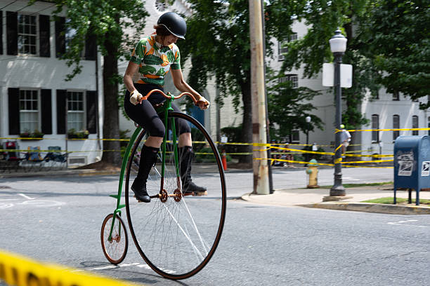 Bangkok, Thailand - April 25, 2014: Capture of a Thai teen couple cycling in street Chokchai 4 in Bangkom Ladprao. In background a car is parked. Girl is standing behind guy on bicycle.