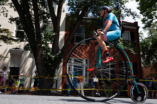 FREDERICK, MARYLAND, USA  JULY 12, 2025: Cyclists prepare for the National Clustered Spires High Wheel Race, the only event of its kind in the United States, by warming up and getting accustomed to their penny-farthing bicycles. Racers from around the world gather in downtown Frederick, where spectators line the barriers on a sunny summer day to watch participants speed through the streets in this unique and lively competition featuring vintage high-wheel bikes.