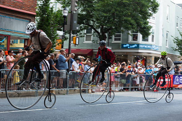 FREDERICK, MARYLAND, USA  JULY 12, 2025: Cyclists race penny-farthings in the National Clustered Spires High Wheel Race, the only event of its kind in the United States, drawing participants from around the world to speed through the streets of downtown Frederick. Spectators line the barriers on a sunny summer day in historic Frederick, cheering on riders as these vintage high-wheel bicyclesalso known as penny-farthingscompete in this unique and lively race.