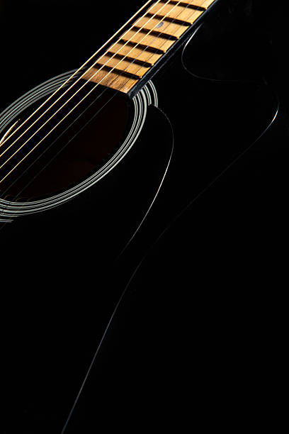 istock black acoustic guitar on a black background, silhouette. close-up, front-side view 2226731099