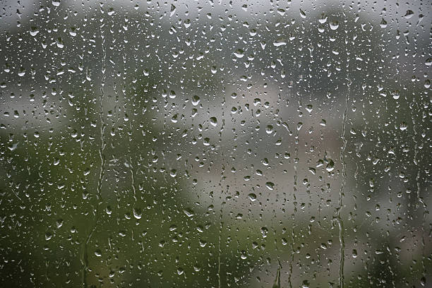 istock Rain Drops on Glass Window With Blurry Outdoor Background in Focus 2226731132