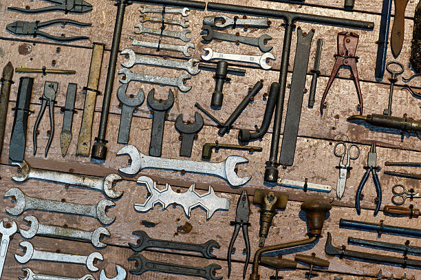 Various old tools hanging on a wooden board evoke a sense of nostalgia and vintage charm