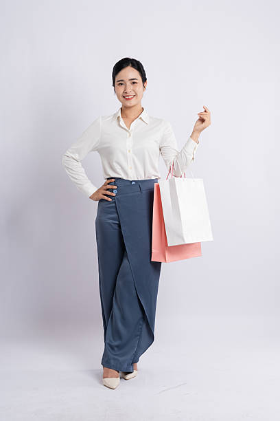 istock Smiling shopper with a fresh purchase dressed stylishly in blue pants and a white blouse 2226733620