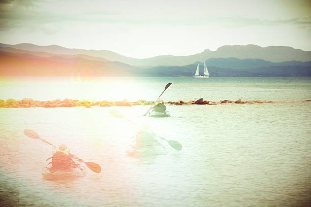 A young kayaker paddles towards the  distance with multiple versions leaving a trail behind. Digital twin concept.