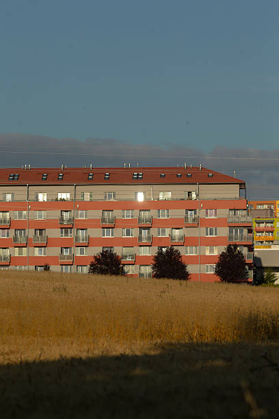 istock A large building with a striking red roof is in a vast field 2226739978