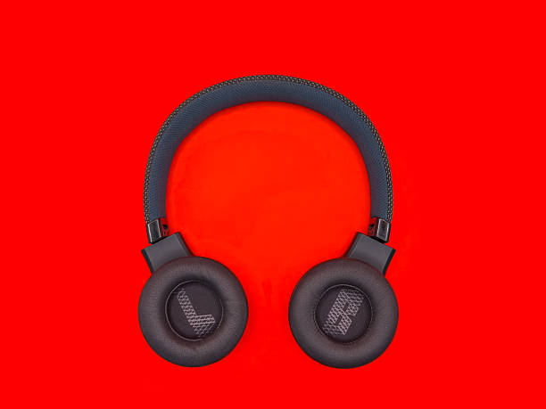 Dark green big headphones on a plain bright red background for banners, for advertising. copy space