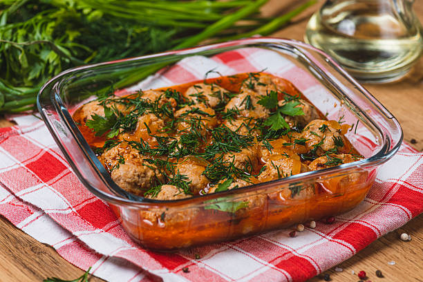 Meatballs in tomato sauce in a baking dish with herbs
