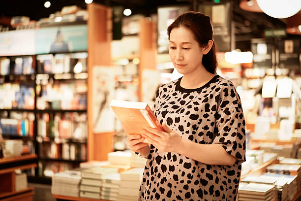 istock Woman reading a book in a cozy bookstore environment 2226742846