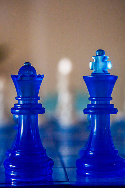 istock Two vibrant blue chess pieces, a king and queen, stand in sharp focus against a softly blurred background 2226749183