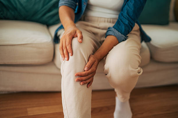istock Senior woman experiencing knee pain while sitting on sofa 2226750353