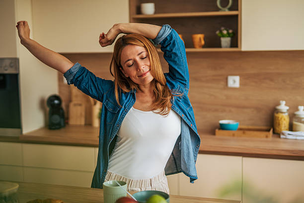 istock Young woman stretching in modern kitchen 2226750418