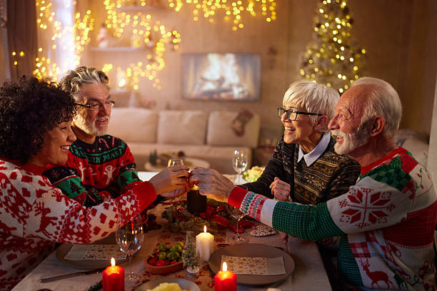istock Happy senior couples toasting on Christmas lunch in dining room. 2226750433