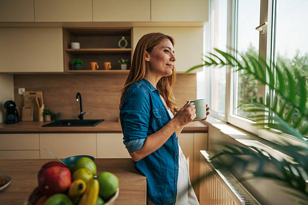 istock Serene woman enjoying morning coffee by kitchen window 2226750585