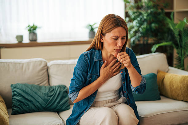 istock Sick woman coughing at home on sofa, suffering from cold or flu 2226750692