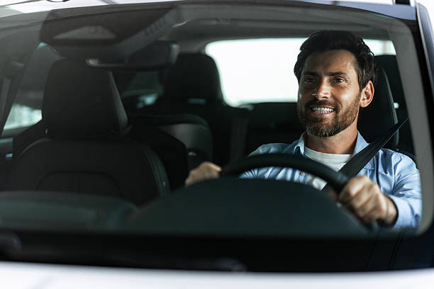 istock Happy man driving a modern car smiling and looking away 2226755771
