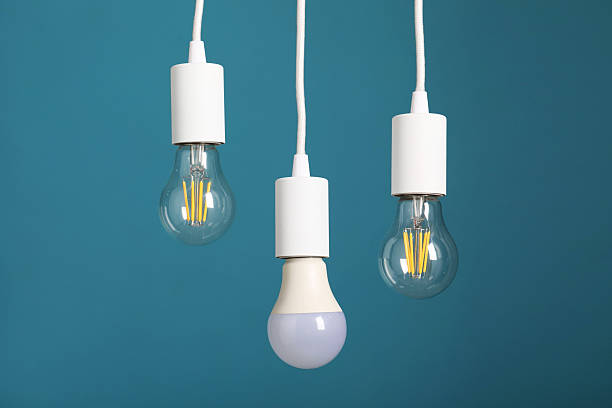 istock Light bulbs hanging on cords against light blue background 2226762106