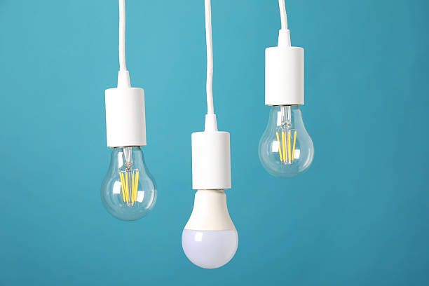 istock Light bulbs hanging on cords against light blue background 2226762138