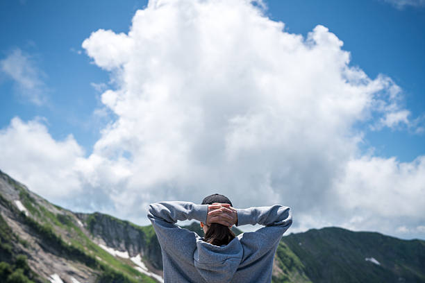 Description: Enthusiastic mountaineer enjoys Jungfrau summit with  panoramic mountain view the background. Jungfrau-Höhenweg, Bernese Alps, Switzerland, Europe.