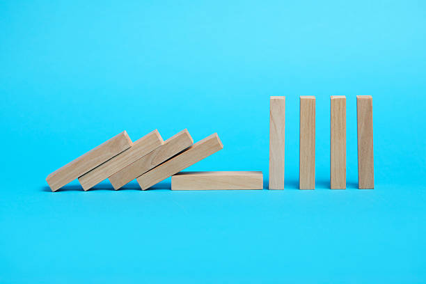 istock Domino effect. Wooden blocks falling on light blue background 2226763119