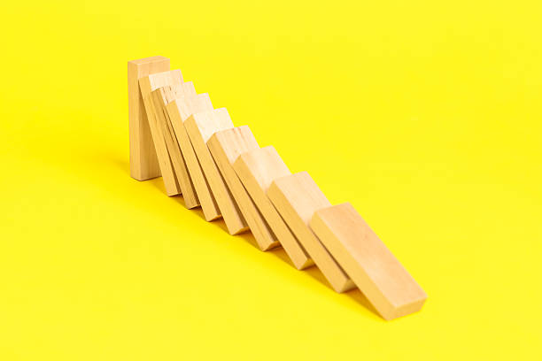 istock Domino effect. Wooden blocks falling on yellow background, closeup 2226763153