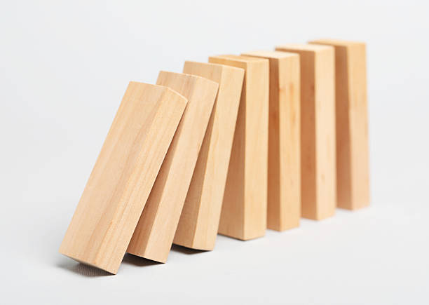 istock Domino effect. Wooden blocks falling on light background 2226763170
