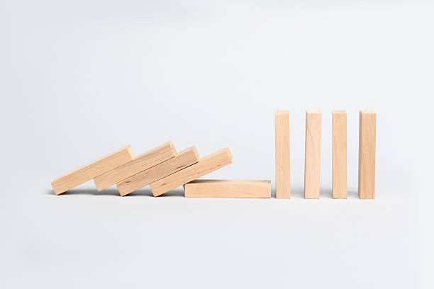 istock Domino effect. Wooden blocks falling on light background 2226763172