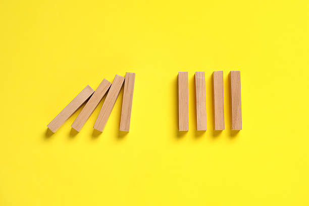 istock Domino effect. Wooden blocks on yellow background, flat lay 2226763217