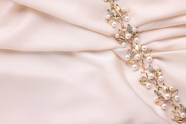 Beautiful bracelet with pearls on beige cloth, top view. Space for text