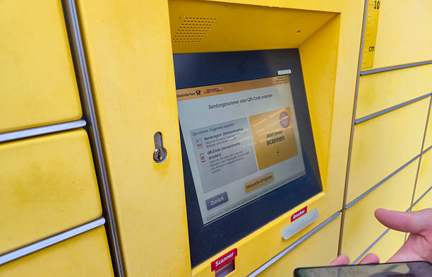 Lahde, Germany - April 15 2025: A person interacting with a DHL package drop-off kiosk, scanning a QR code for sending or receiving packages in an urban setting.