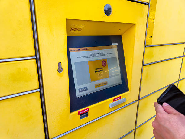 Lahde, Germany - April 15 2025: A person interacting with a DHL parcel locker, entering information on a digital screen, showcasing modern delivery solutions.