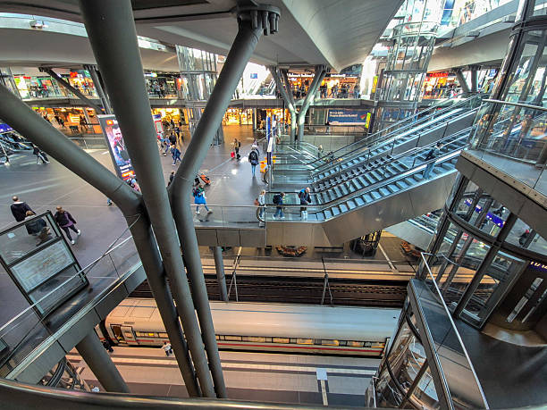 Berlin, Germany - April 16, 2025: Passengers navigate bustling Berlin Hauptbahnhof station, showcasing modern architecture and vibrant atmosphere within a transit hub.