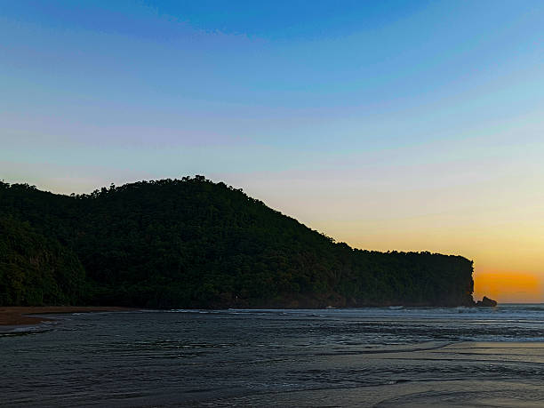 istock Tropical beach with hills and calm ocean during sunset. 2226784788