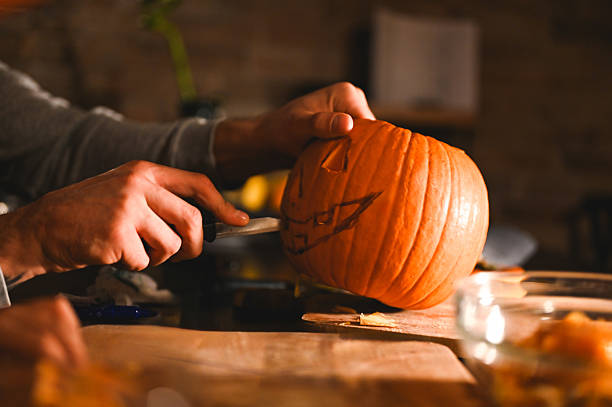 istock Hands carving a pumpkin to make a jack-o'-lantern for halloween 2226785118