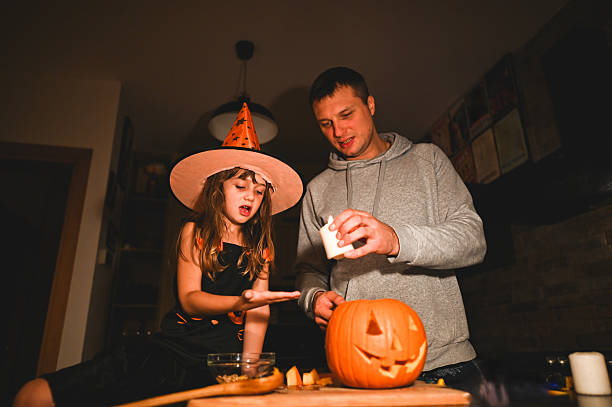 istock Father and daughter carving a jack-o'-lantern for halloween night 2226785583