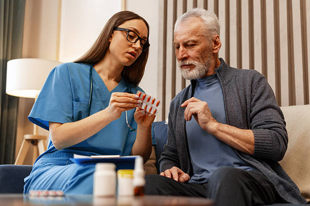 istock Nurse explaining medicine to senior man at home visit sitting on comfortable sofa 2226789657