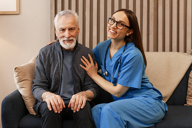 istock Nurse comforting elderly man sitting on sofa at home 2226789663