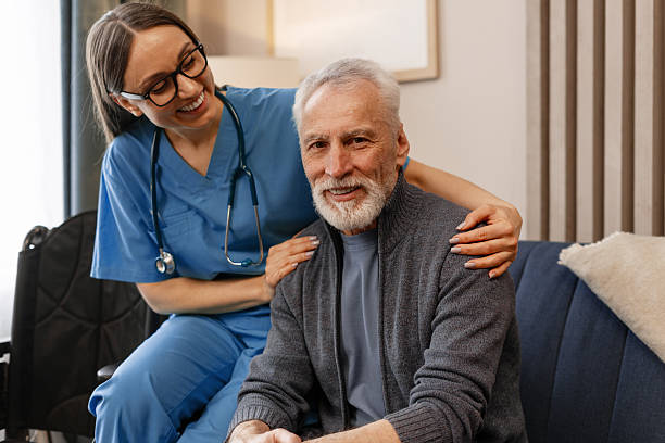 istock Nurse supporting smiling senior man sitting on sofa at home 2226789667