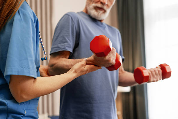 istock Senior man lifting weights with nurse assistance during rehabilitation exercise 2226789687